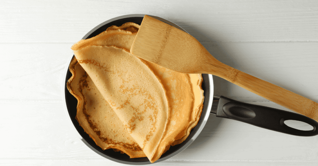 Meilleurs poêles à crêpes utilisés pour cuire des crêpes avec une spatule.