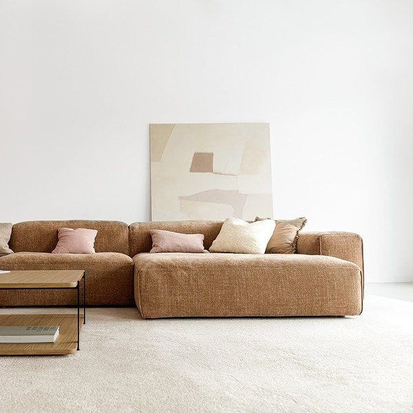 Un salon avec un canapé beige et une table basse imaginés par Quatuor Design.