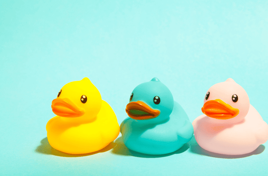 Meilleurs jouets de bain : Trois canards de bain sur un fond bleu.