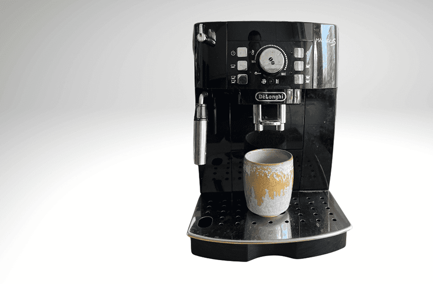 Une machine à café noire DeLonghi Magnifica S avec une tasse de café.