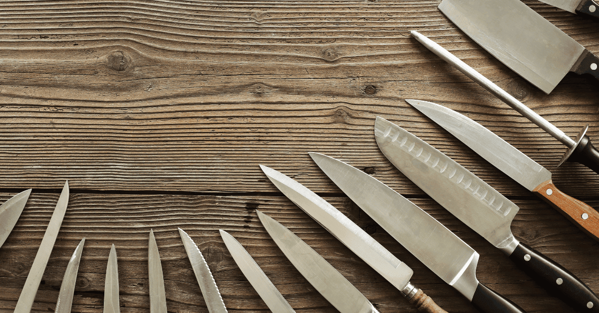 Les meilleurs couteaux de cuisine disposés en cercle sur une table en bois.