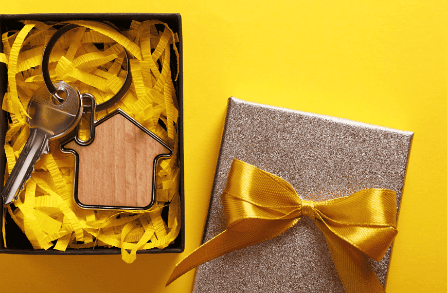 Un coffret cadeau avec une maison en bois et un porte-clés pour pendaison de crémaillère.